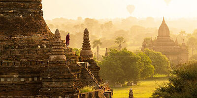 Moine et montgolfières au lever du soleil sur les pagodes de Bagan - Birmanie