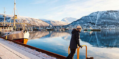 Teenage noy outdoors on winter day enjoying views of Tromso Norway
